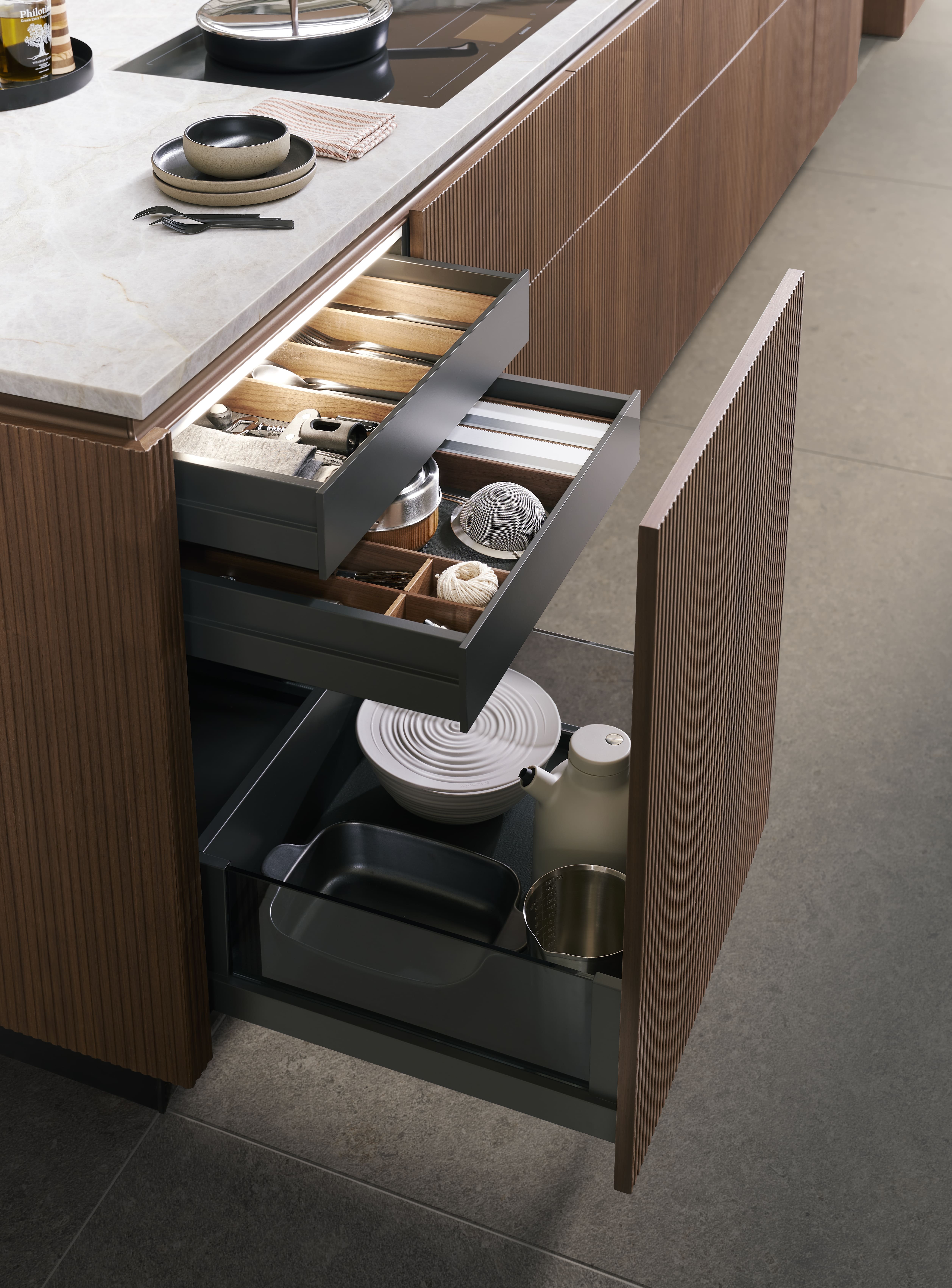 Cuisine haut de gamme en noyer, au design minimal et sans poignées, offrant des lignes épurées, des matériaux nobles et une ambiance moderne et élégante