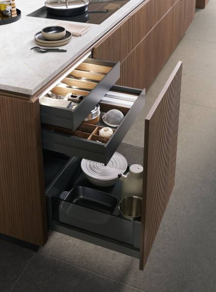 Cuisine haut de gamme en noyer, au design minimal et sans poignées, offrant des lignes épurées, des matériaux nobles et une ambiance moderne et élégante