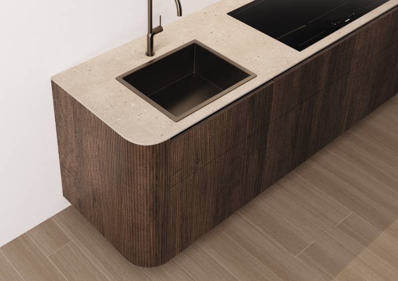 Cuisine haut de gamme en noyer, au design minimal et sans poignées, offrant des lignes épurées, des matériaux nobles et une ambiance moderne et élégante